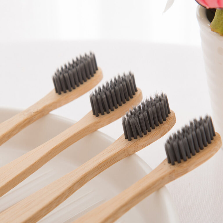 Bamboo toothbrush with wooden bamboo handle and charcoal bristles for hotels and guesthouses