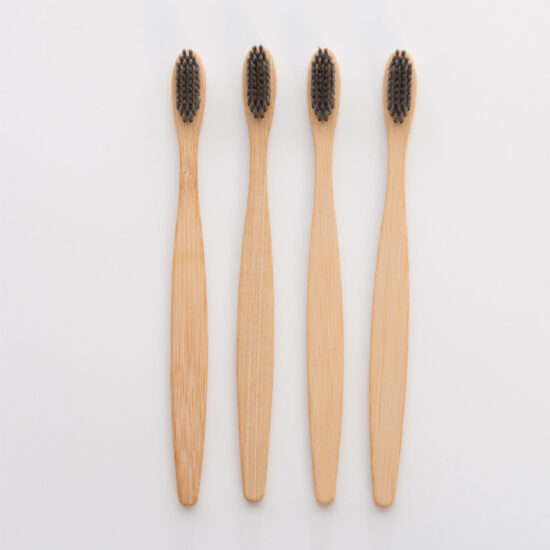 Bamboo toothbrush with wooden bamboo handle and charcoal bristles for hotels and guesthouses