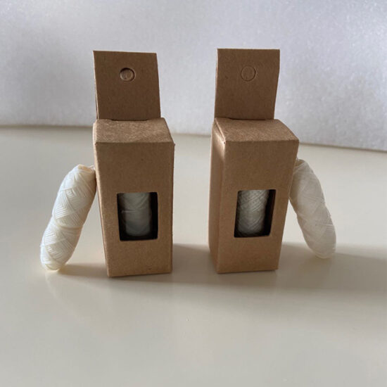 Mint-flavored charcoal and corn fiber dental floss in glass bottle with kraft box