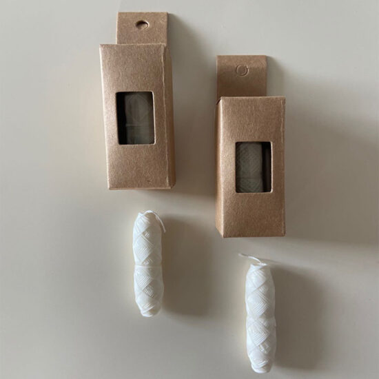Mint-flavored charcoal and corn fiber dental floss in glass bottle with kraft box